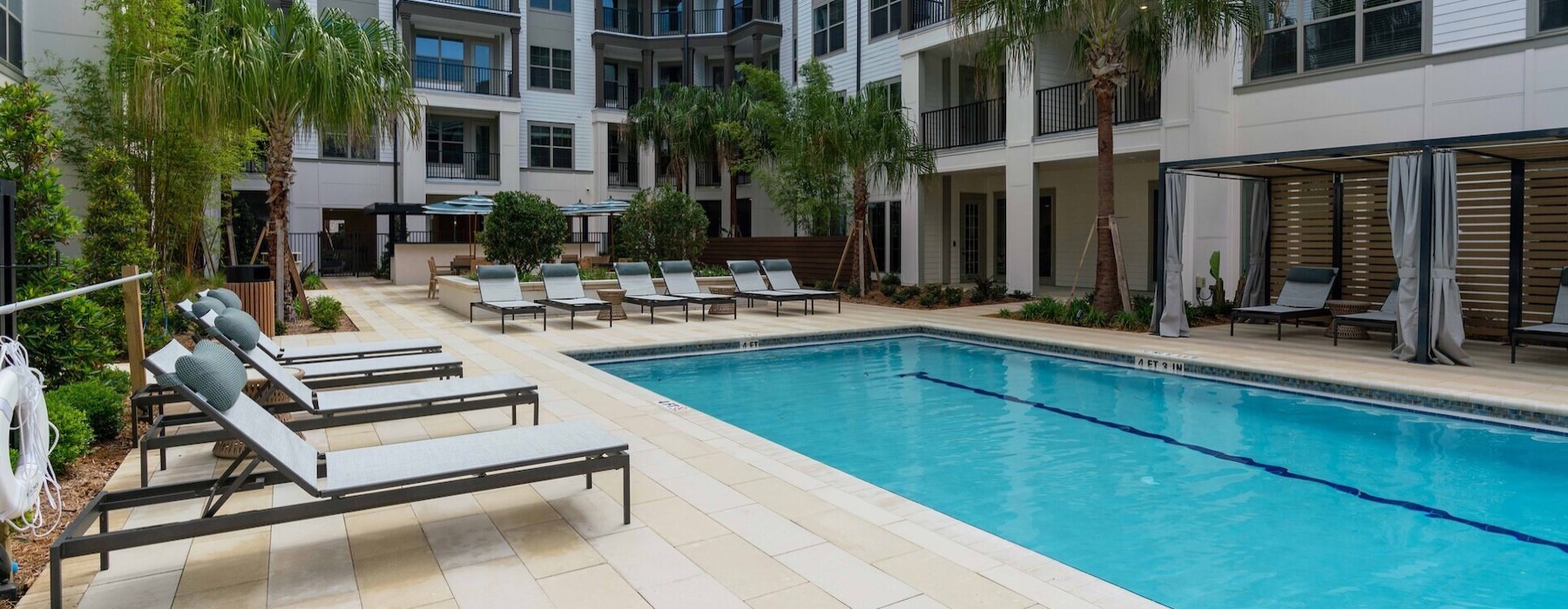 swimming pool in a courtyard with lounge chairs