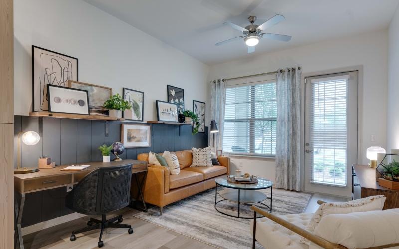 a living room with a desk and a chair